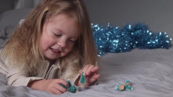 Bonita Niña Jugando Con Pequeños Árboles Navidad Acostados Cama Dormitorio — Vídeos de Stock