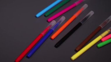 Siyah arkaplanda parlak renkli işaretler var. Sanat, acı, yazı, kırtasiye, keçeli kalem. Yüksek kaliteli FullHD görüntüler