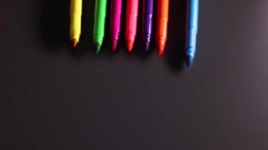 Siyah arkaplanda parlak renkli işaretler var. Sanat, acı, yazı, kırtasiye, keçeli kalem. Yüksek kaliteli FullHD görüntüler