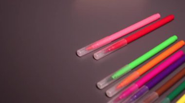 Siyah arkaplanda parlak renkli işaretler var. Sanat, acı, yazı, kırtasiye, keçeli kalem. Yüksek kaliteli FullHD görüntüler