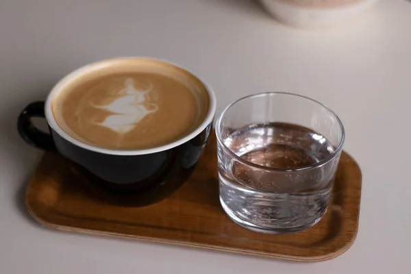 Šálek Kávy Latté Nebo Cappuccino Sklenicí Vody Dřevěném Podnosu Interiér — Stock fotografie