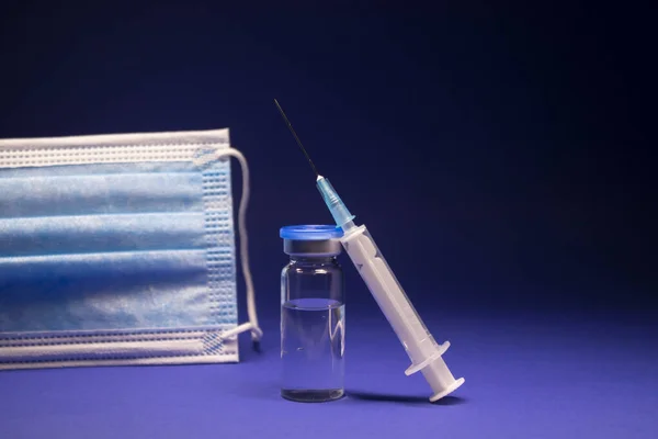 Mavi Tıbbi Maskenin Yanında Etiketsiz Aşı Şişesi Şişesi Enjeksiyonlu Tıbbi — Stok fotoğraf