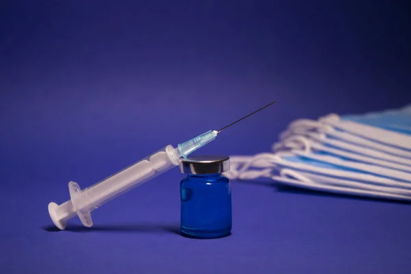 Üzerinde Etiket Olmayan Aşı Şişesi Şişesi Mavi Tıbbi Maske Yığınının — Stok fotoğraf