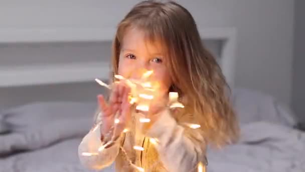 Bonita niña jugando con la guirnalda de Navidad. Año Nuevo, infancia, hija. Imágenes de FullHD — Vídeo de stock