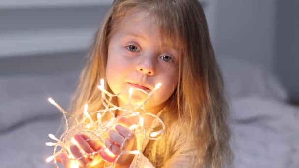 Bonita niña jugando con la guirnalda de Navidad. Año Nuevo, infancia, hija. Imágenes de FullHD — Vídeo de stock