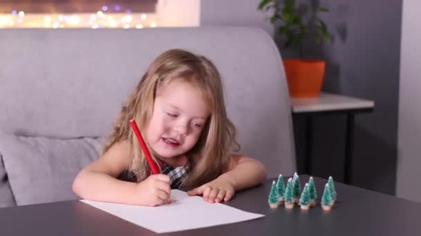 Encantadora niña escribiendo carta a Santa Claus en habitación gris. Año nuevo, infancia, navidad. Imágenes de FullHD — Vídeos de Stock