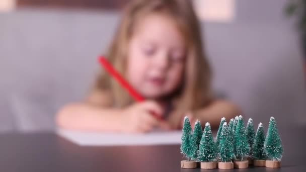 Encantadora niña escribiendo carta a Santa Claus en habitación gris. Año nuevo, infancia, navidad. Imágenes de FullHD — Vídeo de stock