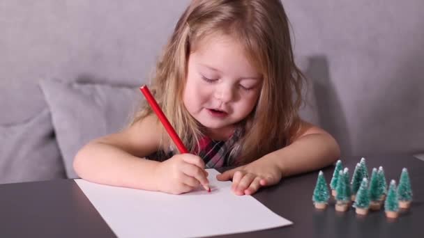 灰色の部屋にサンタ・クラスに手紙を書くチャーミングな少女。新年、子供時代、クリスマス。フルHD映像 — ストック動画