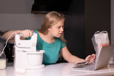 Sarışın bir kadın video blogcu mutfakta yemek pişiriyor ve filme çekiyor, online öğreniyor ya da uzaktan aşçılık dersi alıyor. Canlı yayındayız. yemek pişirme dersi