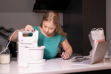 Sarışın bir kadın video blogcu mutfakta yemek pişiriyor ve filme çekiyor, online öğreniyor ya da uzaktan aşçılık dersi alıyor. Canlı yayındayız. yemek pişirme dersi