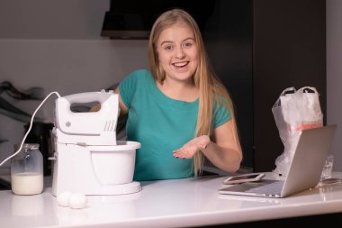 Sarışın bir kadın video blogcu mutfakta yemek pişiriyor ve filme çekiyor, online öğreniyor ya da uzaktan aşçılık dersi alıyor. Canlı yayındayız. yemek pişirme dersi