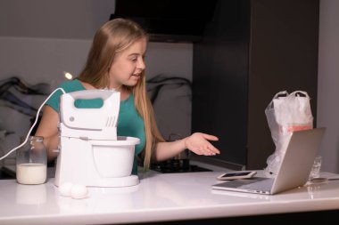 Sarışın bir kadın video blogcu mutfakta yemek pişiriyor ve filme çekiyor, online öğreniyor ya da uzaktan aşçılık dersi alıyor. Canlı yayındayız. yemek pişirme dersi