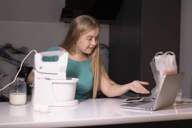 Sarışın bir kadın video blogcu mutfakta yemek pişiriyor ve filme çekiyor, online öğreniyor ya da uzaktan aşçılık dersi alıyor. Canlı yayındayız. yemek pişirme dersi