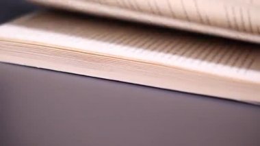 Macro kitabın sayfalarını çevirirken çekti. Sayfaların sayfalarını kapatıyoruz. Öğrenme ve eğitim kavramı. Masadaki kitap sayfalarında tanımlanamayan metnin ayrıntılı görünümü