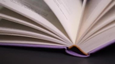 Menekşe kitabının kapanış sahnesi. Sayfaları çevirmeye yaklaştık. Okuma konsepti aşkı. Sayfalar üzerindeki tanımlanamayan metnin ayrıntılı görünümü