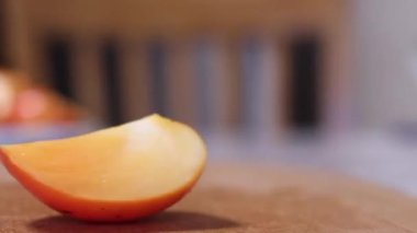 Tahta kesme tahtasında dilimlenmiş taze portakal hurması. diyet. egzotik tropikal meyveler