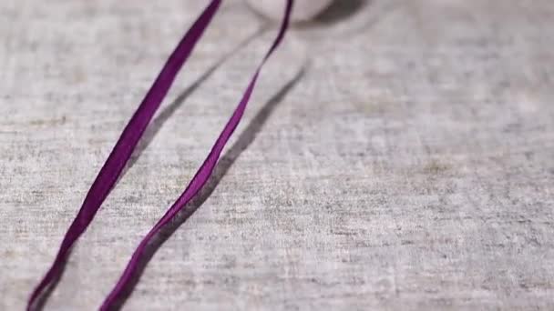 用紫色丝带系在灰色背景上的鸡蛋 复活节 — 图库视频影像