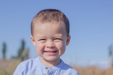 Tarlada mavi etekli güzel bir çocuğun portresi.