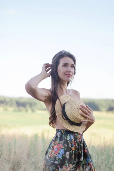 トップレスブルネットの女性カバー彼女の胸で野に藁帽子 — ストック写真