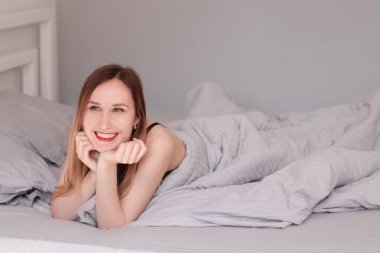 Gri çarşaflı, siyah dantelli iç çamaşırlı güzel kızıl kadın..