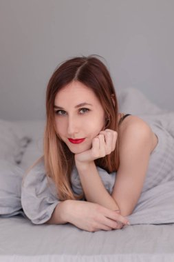 Gri çarşaflı, siyah dantelli iç çamaşırlı güzel kızıl kadın..