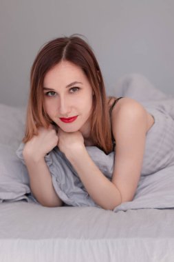 Gri çarşaflı, siyah dantelli iç çamaşırlı güzel kızıl kadın..