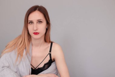 Gri çarşaflı ve battaniyeli siyah iç çamaşırlı güzel kızıl saçlı kadının portresi..