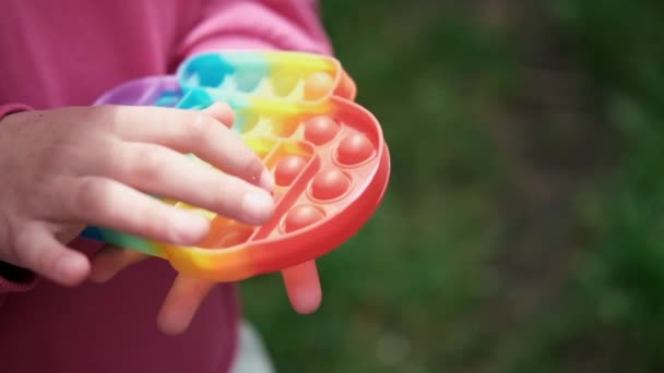 Kind unkenntlich Hände spielen trendige Silikon zappelnde Spiel sensorischen Spielzeug Pop es. regenbogenweiche Silikonblasen. Angstlinderung, Antistress, Konzept für psychische Gesundheit. Anti-Stress-Spiel popit. Zeitlupe — Stockvideo