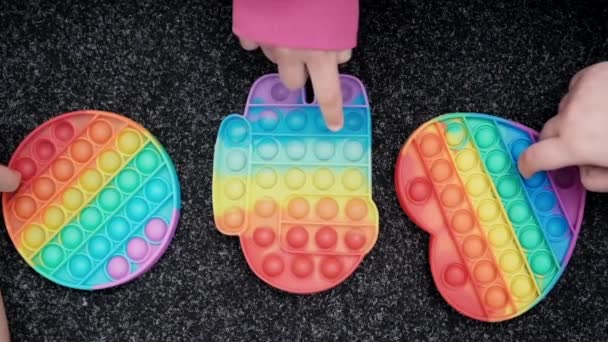Child unrecognizable hands play trendy silicon fidgeting game sensory toy pop it. rainbow soft silicone bubbles. anxiety relief, antistress, mental health concept. Anti stress game popit. slow motion — 비디오