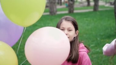 Pembe kazaklı tatlı esmer kız sıcak hava balonlarıyla eğleniyor. Mutlu yaz günleri, tatiller, tatiller. yavaş çekim.