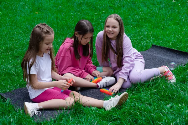 Tres Chicas Adolescentes Ropa Colorida Juegan Con Juguete Sensorial Moda —  Fotos de Stock
