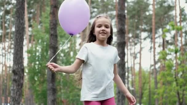 Pretty preschool girl having fun playing with hot air balloons outdoors. hollidays, party, birthday, celebration. happy children. slow motion — Stock Video