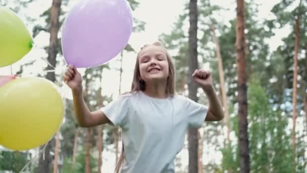 Hezká školka dívka baví hrát s horkovzdušné balónky venku. svátky, párty, narozeniny, oslavy. Šťastné děti. zpomalený pohyb — Stock video