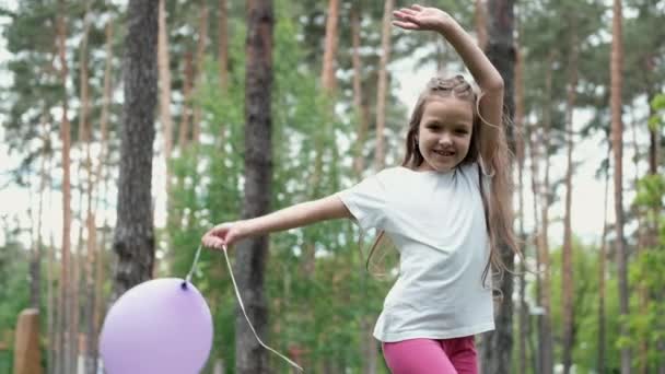 Pretty preschool girl having fun playing with hot air balloons outdoors. hollidays, party, birthday, celebration. happy children. slow motion — Stock Video