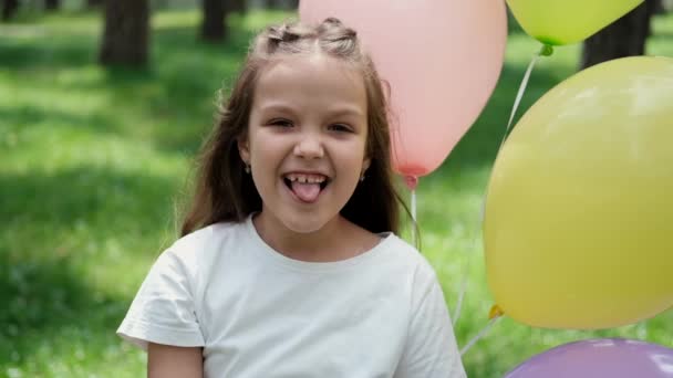 Bastante niña preescolar divertirse jugando con globos de aire caliente al aire libre. vacaciones, fiesta, cumpleaños, celebración. niños felices. cámara lenta — Vídeos de Stock