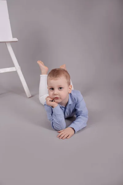 Niño Rubio Preescolar Pantalones Blancos Camisa Azul Sobre Fondo Gris —  Fotos de Stock