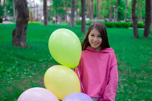 ピンクの10代のブルネットの女の子の間にカラフルな熱気球を屋外で保持している パーティー 誕生日のコンセプト 幸せな子供たち 休日や夏休み — ストック写真