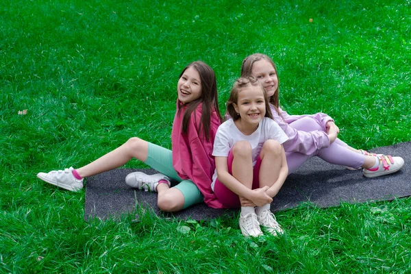 Tres Hermosas Niñas Adolescentes Felices Ropa Colorida Sentada Sobre Hierba —  Fotos de Stock