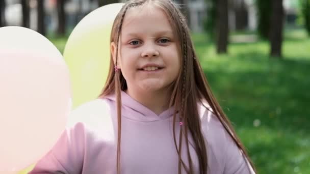 紫の衣装を着た10代の女の子が熱気球で屋外で遊んでいます 祝日パーティー誕生日お祝い 幸せな子供たち スローモーション — ストック動画