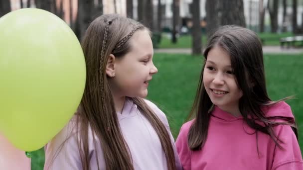 Twee Tienerschoolmeisjes Die Plezier Hebben Buiten Kleurrijke Kleding Bij Heteluchtballonnen — Stockvideo