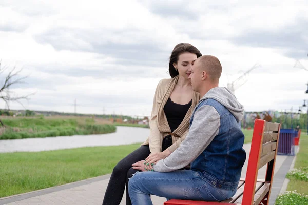 stock image beautiful young couple sitting on a bench in the park.