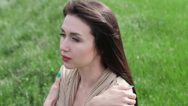 Krásná brunetka žena sedí na zelené trávě — Stock video