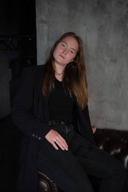 Gri karanlık odadaki siyahlı güzel, kendine güvenen esmer kadının portresi. İş kadını. Kadınsı. Milenyum insanları. şık moda kıyafetleri..