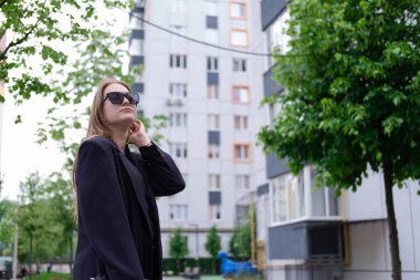 Parlak modern binaların arka planında güzel esmer bir kadın. Kadınsı. Milenyum insanları. Yürüyen bayan..