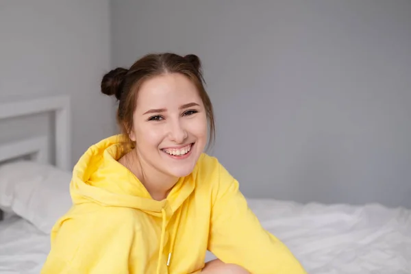 Feliz Chica Morena Alegre Sudadera Con Capucha Amarilla Dormitorio Blanco —  Fotos de Stock