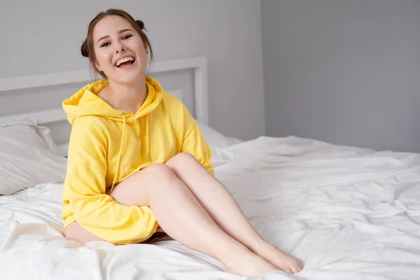 Feliz Chica Morena Alegre Sudadera Con Capucha Amarilla Dormitorio Blanco —  Fotos de Stock