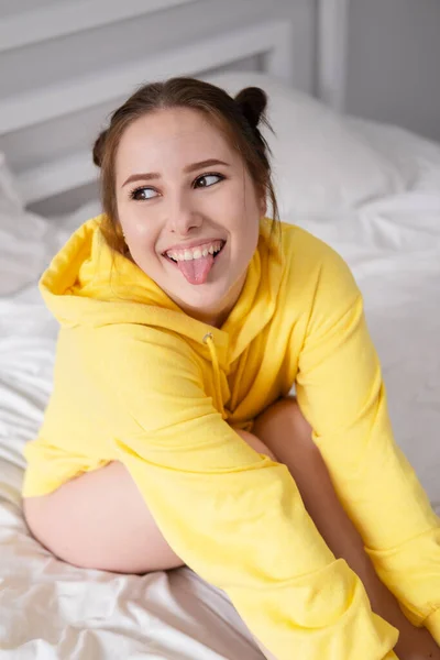 Vrolijke Positieve Brunette Vrouw Gele Hoodie Witte Slaapkamer Bed Met — Stockfoto