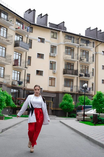 Mujer Morena Confiada Pantalones Rojos Blusa Blanca Chaqueta Caminando Calle —  Fotos de Stock