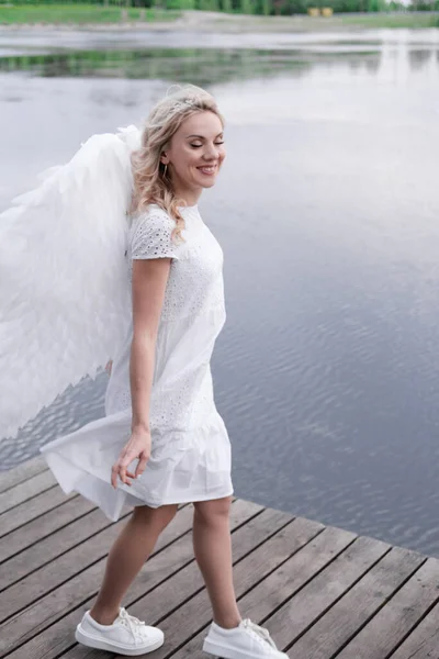 Beyaz elbiseli ve beyaz melek kanatlı sarışın kadın portresi. İyi insanlar. Tanrım, cennet. Cennet meleği — Stok fotoğraf
