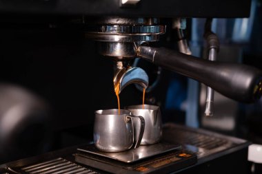 Profesyonel kahve makinesinden sade kahve dökülüyor. Kahve yapan barista. Koyu kahve dükkanı.